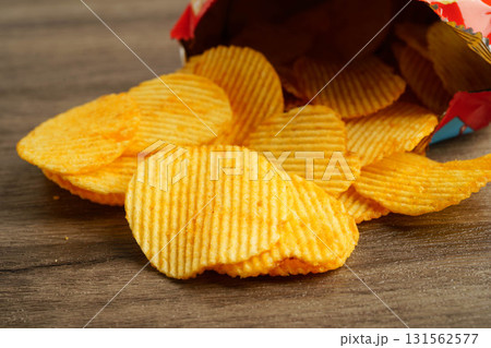 Potato chips in open bag, delicious BBQ seasoning spicy for crips, thin slice deep fried snack fast food. 131562577