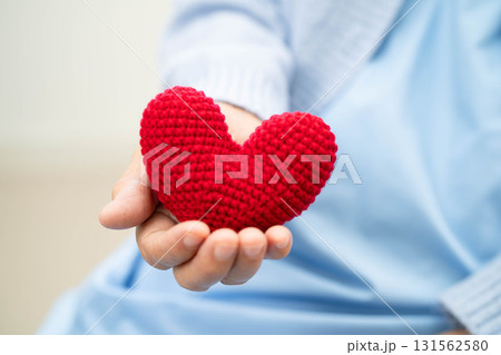 Asian elder senior woman patient holding red heart in hospital. 131562580
