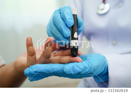 Asian woman self testing to check blood sugar level diabetes by digital lancet on finger at home. Asian woman self testing to check blood sugar level diabetes by digital lancet on finger at home. 131562619