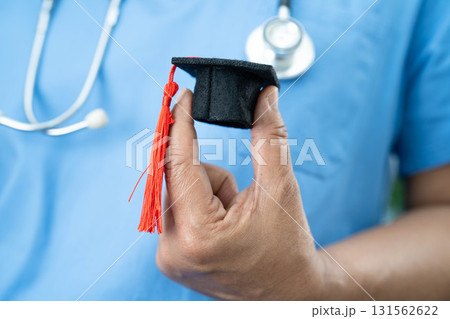 Asian woman doctor holding graduation hat in hospital, Medical education concept. Asian woman doctor holding graduation hat in hospital, Medical education concept. 131562622
