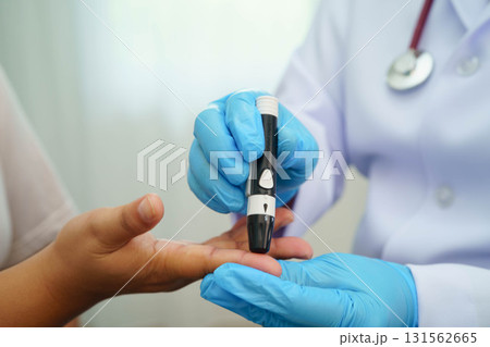 Asian woman self testing to check blood sugar level diabetes by digital lancet on finger at home. Asian woman self testing to check blood sugar level diabetes by digital lancet on finger at home. 131562665