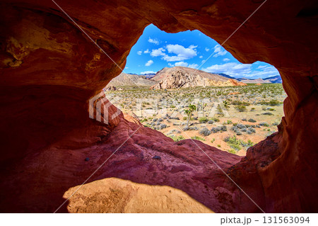 Red Rock Arch Formation with Desert Landscape and Mountains 131563094