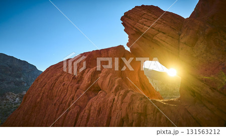 Sunset Arch Formation and Red Rock Landscape in Golden Hour Light 131563212