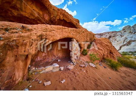 Red Rock Cave and Stone Wall in Desert Landscape Under Blue Sky Red Rock Cave and Stone Wall in Desert Landscape Under Blue Sky 131563347