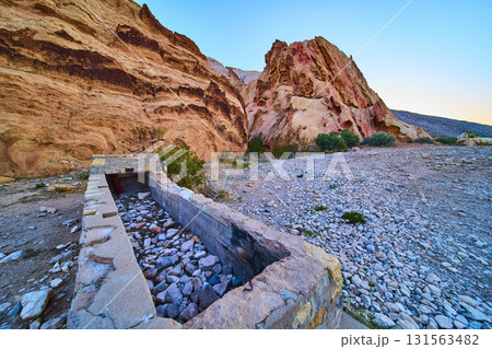 Stone Cistern and Red Rock Formations in Desert Landscape 131563482