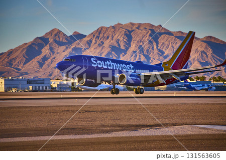 Airplane taxiing at Las Vegas airport Nevada with city skyline and mountains in background 131563605