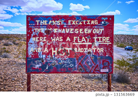 Weathered Red Desert Sign with Bullet Holes and Graffiti in Nevada Desert Weathered Red Desert Sign with Bullet Holes and Graffiti in Nevada Desert 131563669