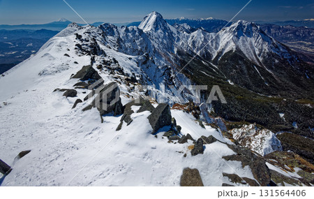冬の八ヶ岳連峰・横岳から見る富士山と赤岳・阿弥陀岳・南アルプスの山並み 131564406