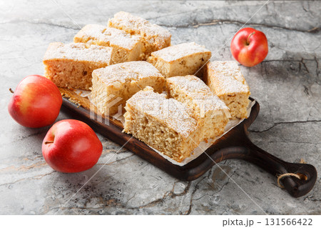 Applesauce cake with warm spices like cloves, ginger, and cinnamon close-up on a wooden board. Horizontal Applesauce cake with warm spices like cloves, ginger, and cinnamon close-up on a wooden board. Horizontal 131566422