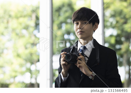 カメラを持つスーツの男性 131566495