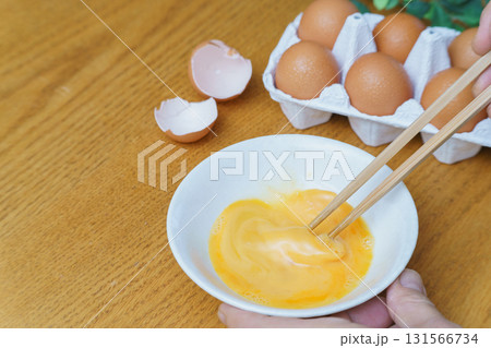 生卵を割って混ぜる 131566734