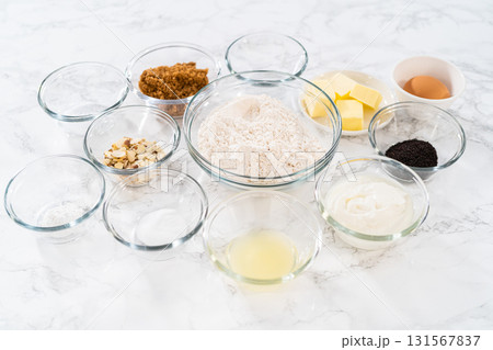 Measured ingredients in glass mixing bowls to bake lemon poppy seed muffins. 131567837