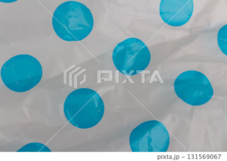 Wrinkled opaque plastic background with blue dotted pattern textured plastic surface close-up 131569067