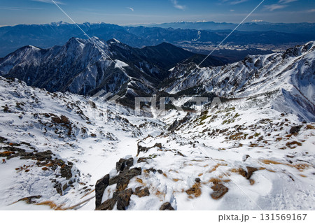 冬の八ヶ岳連峰・赤岳山頂から見る権現岳と南アルプス・中央アルプスの山並み 131569167