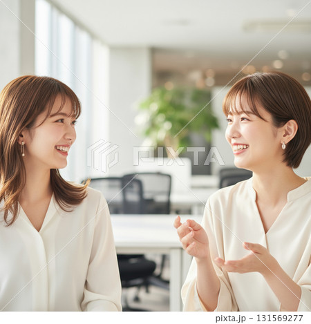 ビジネスシーン:談笑する若い女性会社員のポートレート 優しい陽の光が差す白色基調のモダンなオフィス ビジネスシーン:談笑する若い女性会社員のポートレート 優しい陽の光が差す白色基調のモダンなオフィス 131569277