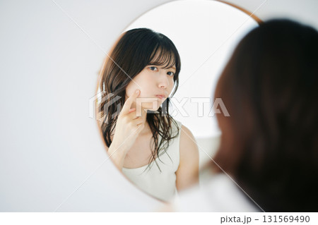 鏡で肌の状態を確認する女性 131569490
