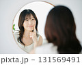 鏡で肌の状態を確認する笑顔の女性 131569491