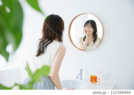 鏡で肌の状態を確認する笑顔の女性 131569494