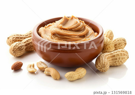 Bowl of peanut butter and peanuts around it on white background. 131569818