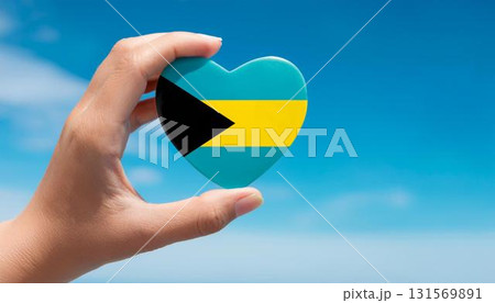 手で持っているバハマの国旗のハートと青空 131569891
