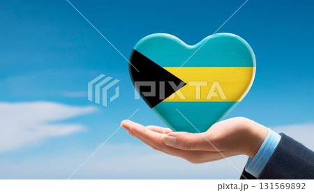 手で持っているバハマの国旗のハートと青空 131569892