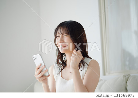 ソファに座ってスマホを持つ女性 131569975