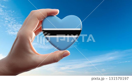 手で持っているボツワナの国旗のハートと青空 131570197