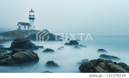 Lighthouse on a rocky coastline with calm misty waves 131570254