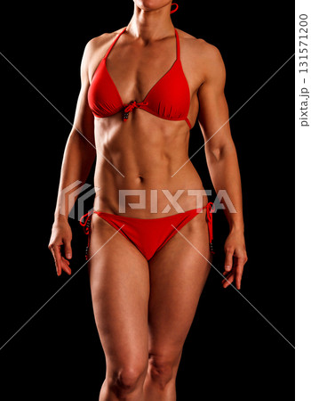 Sexy sports woman in red bikini posing against black background 131571200
