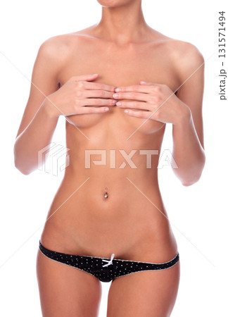 Young slim woman covers her breasts with her fingers, isolated on white background Young slim woman covers her breasts with her fingers, isolated on white background 131571494