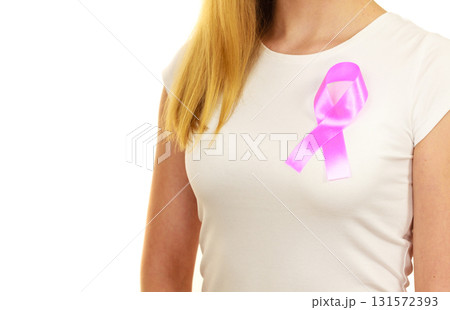 Closeup pink cancer ribbon on woman chest Closeup pink cancer ribbon on woman chest 131572393