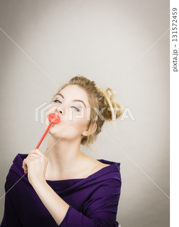 Funny woman holding big red lips on stick Funny woman holding big red lips on stick 131572459