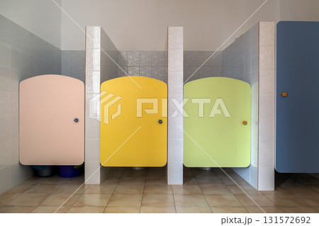 Colorful toilet doors in elementary school bathroom interior. Colorful toilet doors in elementary school bathroom interior. 131572692
