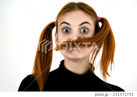 Close up portrait of pretty redhead teenage girl fooling around. 131572733