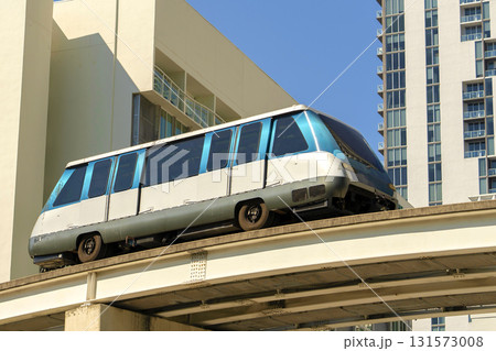 City train car on high railroad over street traffic between skyscraper buildings in modern American megapolis. Urban transportation in downtown district of Miami Brickell in Florida USA City train car on high railroad over street traffic between skyscraper buildings in modern American megapolis. Urban transportation in downtown district of Miami Brickell in Florida USA 131573008