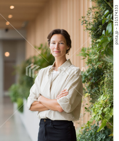 Confident female CEO and professional businesswoman portrait inside sustainable corporate office. successful leader stands with arms crossed, showing determination 131574333