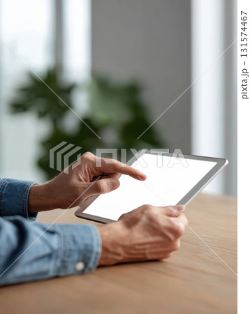 Focused person with hand touching tablet screen, using modern technology for smart home device control. blank mockup screen provides copy space for business ideas 131574467