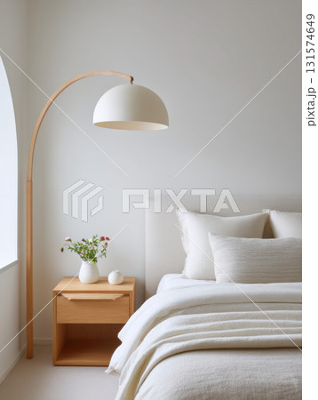 Calm minimalist bedroom interior design with modern home furniture. cozy scene features comfortable bed, wooden nightstand, and stylish arched floor lamp by window 131574649