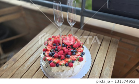 Elegant berry Pavlova cake celebration on wooden table with champagne flutes for special occasion 131574952