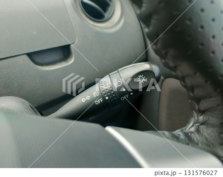 The image displays a car's light and turn signal stalk, typically located on the left side of the steering column. The image displays a car's light and turn signal stalk, typically located on the left side of the steering column. 131576027