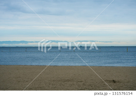 潮芦屋ビーチから見る雲の切れ間に見える山並みのシルエット 潮芦屋ビーチから見る雲の切れ間に見える山並みのシルエット 131576154