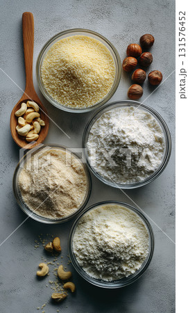 Various type of flour creates visually appealing flat lay in glass bowls, nuts beside them giving off an organic vibe 131576452