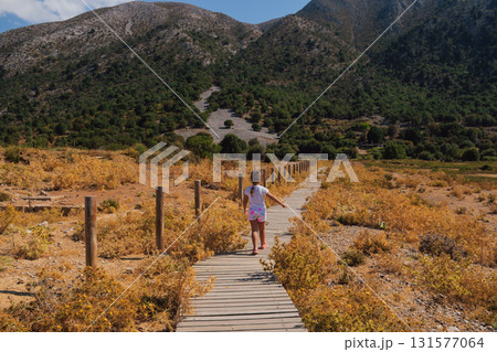 Little girl walking on wooden path in the mountains of Crete. 131577064