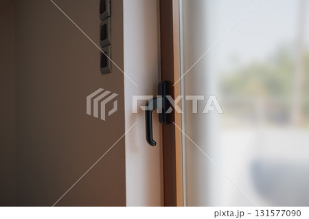 Brown metal plastic balcony door in interior with white walls. Brown metal plastic balcony door in interior with white walls. 131577090