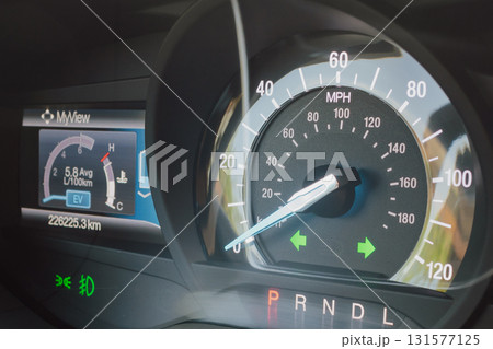 Car dashboard with headlights and hazard lights on. 131577125