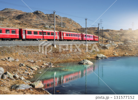 Bernina Express train near lake in Switzerland at sunset Bernina Express train near lake in Switzerland at sunset 131577152