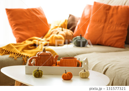 Autumnal living room decor with pumpkins, teapot, tea cup and cozy blankets. Autumnal living room decor with pumpkins, teapot, tea cup and cozy blankets. 131577321