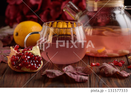 Autumn Beverage: Pomegranate Tea with Lemon and Ginger on Rustic Table 131577333