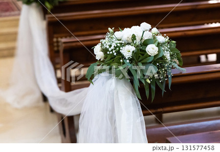 Wedding-ready church with white tulle and flowers Wedding-ready church with white tulle and flowers 131577458