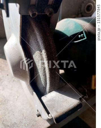 Grinding Wheel Attached to a Machine in a Workshop During Daylight Hours 131577845